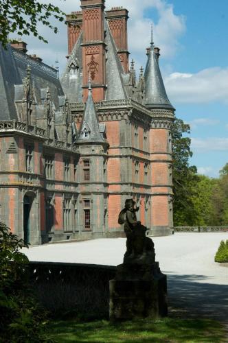 an old castle with a statue in front of it at longère de kervéguen ARGOAT in Leuhan