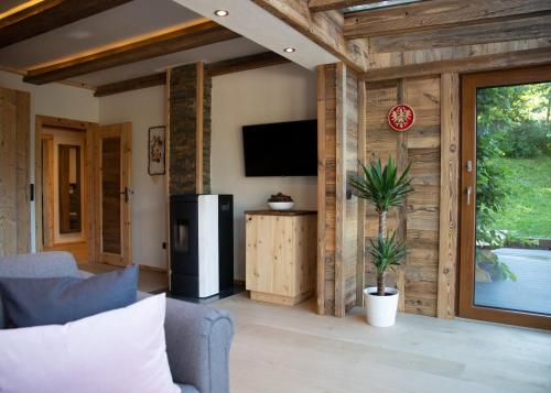 a living room with a couch and a television in a room at Chalet Gletscherblick Stubai in Mieders