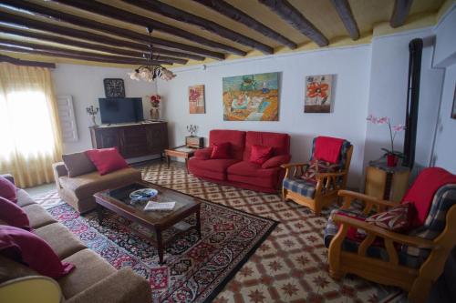 salon z czerwoną kanapą i krzesłami w obiekcie Casa Rural La Casona w mieście Urrea de Gaen
