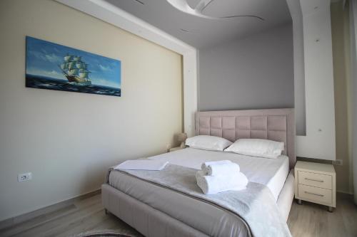 a bedroom with a bed with two towels on it at Apartments Romario in Sarandë
