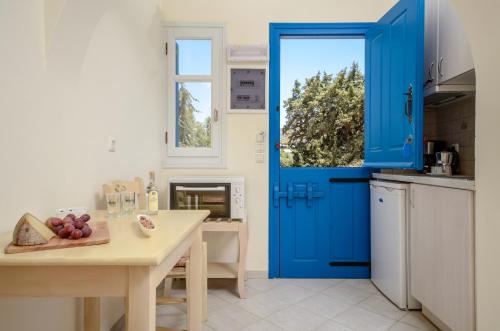 a blue door in a kitchen with a table at Orkos Blue Coast in Mikri Vigla