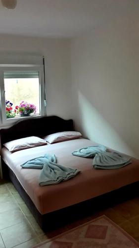 a bedroom with a bed with two robes on it at Apartman Tatjana in Sutomore