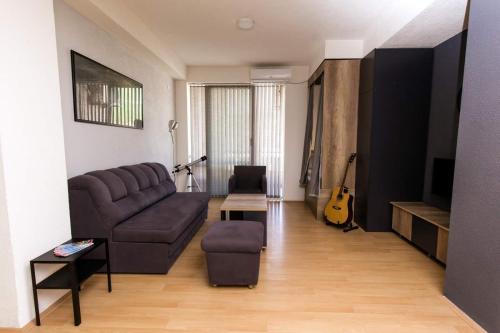un soggiorno con un divano e una chitarra di OZ Apartments a Ohrid