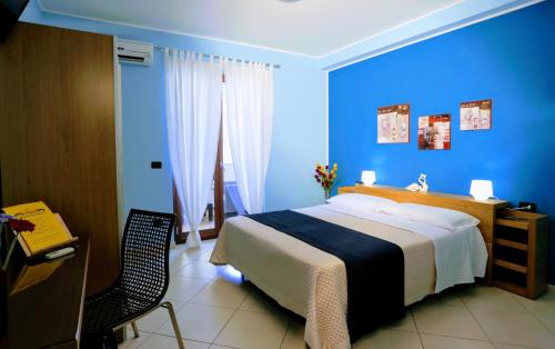 1 dormitorio azul con 1 cama y 1 silla en Zama Bed&Breakfast en Scalea