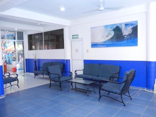 a waiting room with chairs and a blue wall at Hotel Plaza Almendros in Isla Mujeres