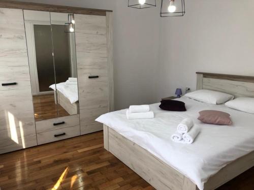 a bedroom with a bed with towels and a mirror at CASA ALISE-LUISE in Braşov