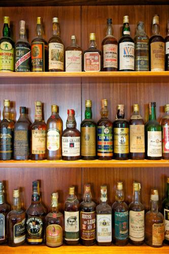 a shelf filled with lots of bottles of alcohol at Mercure Reggio Emilia Centro Astoria in Reggio Emilia