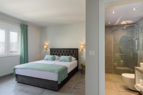 a bedroom with a bed and a glass shower at Villa Gala in Trogir