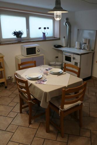 a kitchen with a table with chairs and a tableablish at IL LILLA in Ankaran