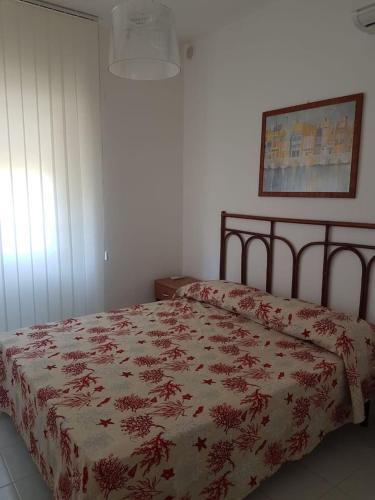 1 dormitorio con 1 cama con manta roja y blanca en Appartamento Corallo, en Casal Velino