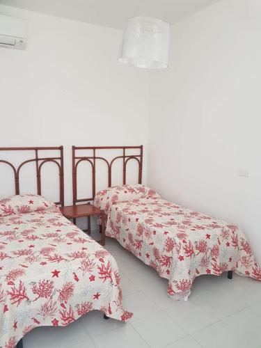 duas camas sentadas uma ao lado da outra num quarto em Appartamento Corallo em Casal Velino