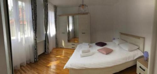 1 dormitorio con 1 cama con sábanas y almohadas blancas en CASA ALISE-LUISE, en Brasov