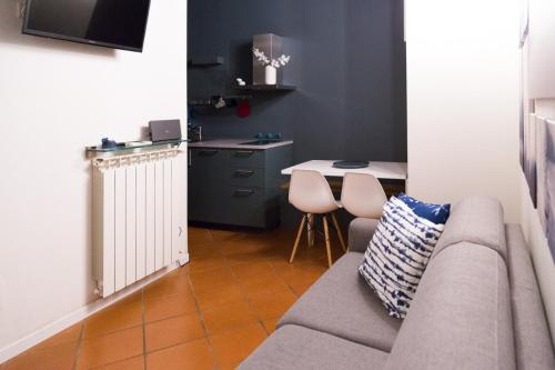 ein Wohnzimmer mit einem Sofa und einem Tisch in der Unterkunft Modena Charme Sant'Eufemia in Modena