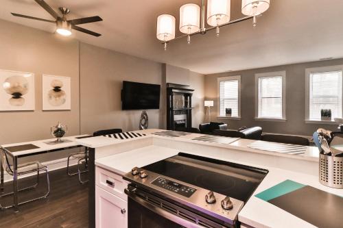 a kitchen with a stove and a living room at Luxury Apt w/ Spectrum Mood Lighting - Historic Cherokee Street Antique Row in Maryland Heights