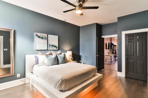 a bedroom with a bed and a ceiling fan at Luxury Apt w/ Spectrum Mood Lighting - Historic Cherokee Street Antique Row in Maryland Heights