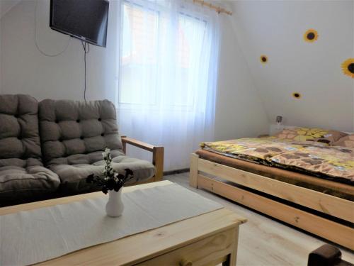 a living room with a couch and a bed at Podkrovní apartmán v Zátiší in Doksy