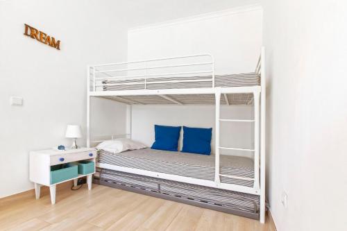 a white bunk bed with blue pillows and a desk at MantaGarden in Manta Rota
