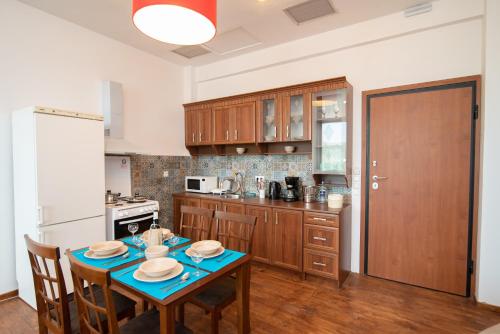 a kitchen with a table with chairs and a refrigerator at Calypso Apartments in Vathi, Ithaka