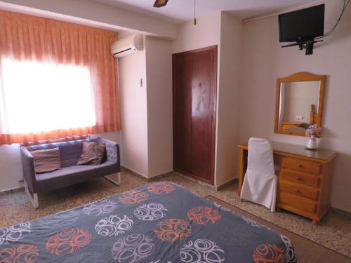 1 dormitorio con cama, sofá y espejo en Hotel Alain en Silla