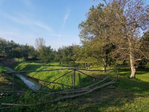une clôture dans un champ avec un ruisseau dans l'établissement u Franciszka w sadzie, à Ciechocinek
