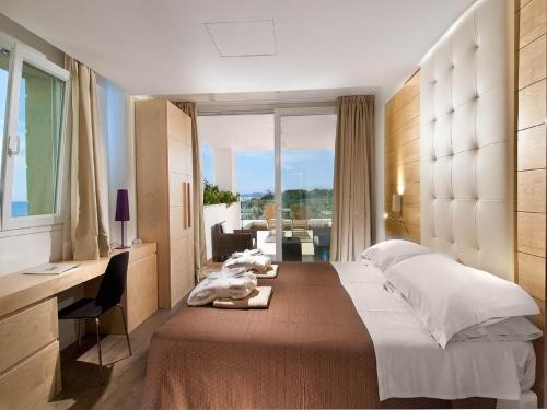 1 dormitorio con cama, escritorio y ventana en Hotel Sarti, en Riccione