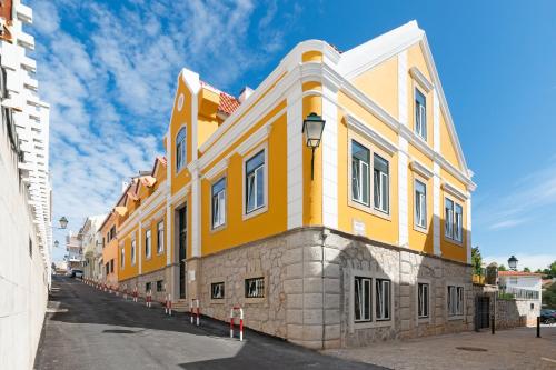 żółty budynek po stronie ulicy w obiekcie Bela Vista Palace Apartments w mieście Cascais