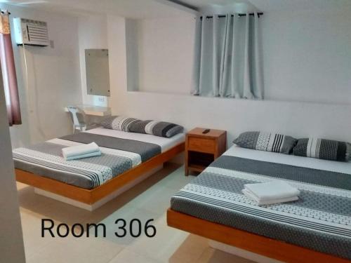 sypialnia z 2 łóżkami i lustrem w obiekcie Eriko's House w mieście Boracay