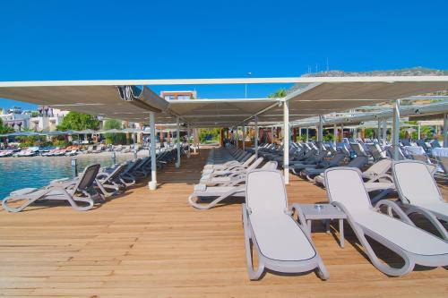 a row of lounge chairs on a dock with the water at Marisol Boutique Hotel in Gundogan