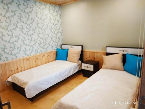 two beds in a room with blue and white at Caspian Star in Sumqayyt