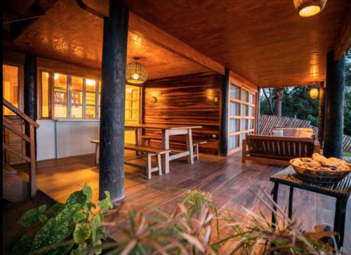 a porch of a wooden cabin with a table and chairs at Coco Ne in Máncora