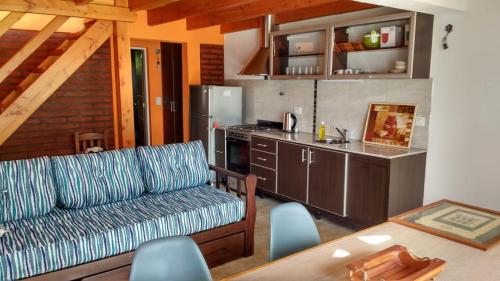 a living room with a couch and a table and a kitchen at Cabañas Cuatro Estaciones in Lago Puelo