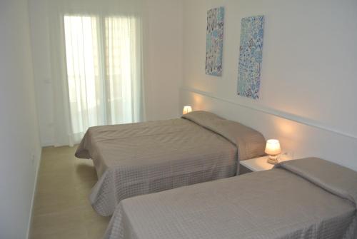 a bedroom with two beds and two lamps on a table at Condominio Shedir in Bibione