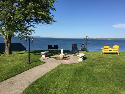 迪格比海风汽车旅馆的公园里有两个黄色长椅和水