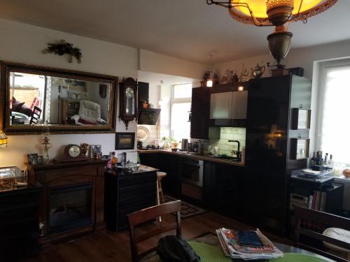 een keuken met zwarte kasten, een tafel en een open haard bij apartament w centrum in Ciechocinek