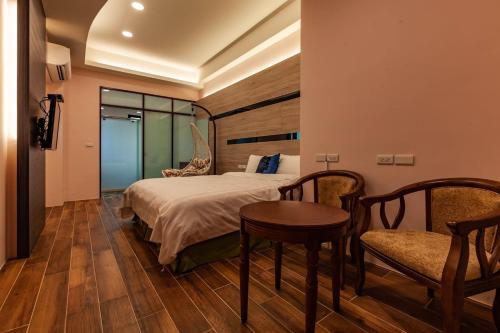 a bedroom with a bed and a table and chairs at 123 Hall in Wujie