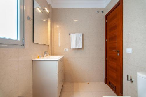 y baño con lavabo, aseo y espejo. en San Remo 1A036, en Palm-mar