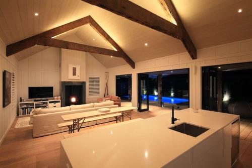 a large living room with a couch and a table at Blackpool Boathouse - Stay Waiheke in Oneroa