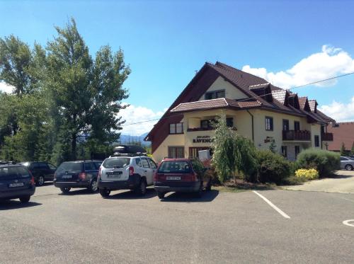 a building with cars parked in a parking lot at Penzion Ravence in Liptovský Trnovec
