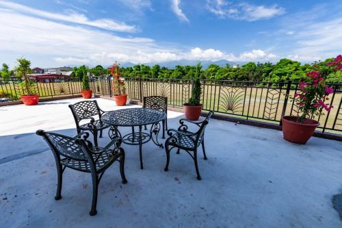 a patio with a table and chairs and a fence at 123 Hall in Wujie