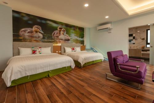 a bedroom with two beds and a purple chair at 123 Hall in Wujie