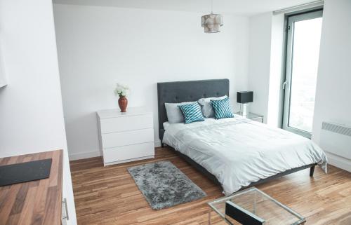 - une chambre blanche avec un lit et une table en verre dans l'établissement Studio Apartments Free street parking subject to availability, à Manchester