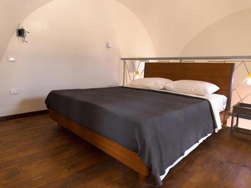 Santa Maria a Vico的住宿－Al Vicolo Stretto，一间卧室设有一张大床,铺有木地板