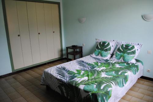 a bedroom with a bed with green leaves on it at Mas de la Vignassa in Le Soler