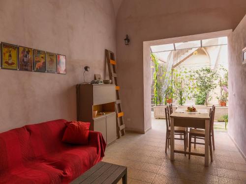 a living room with a red couch and a table at Al Vicolo Stretto in Santa Maria a Vico