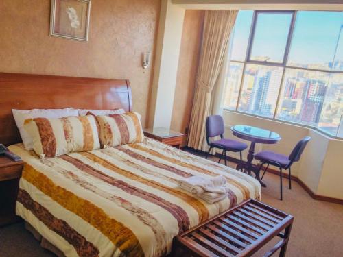 a hotel room with a bed and a large window at Eurotel Davina in La Paz