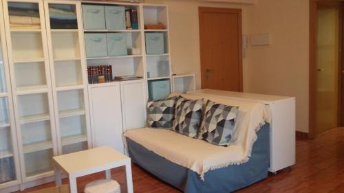 Habitación con sofá y estante para libros en Estudio SALOU, en Salou