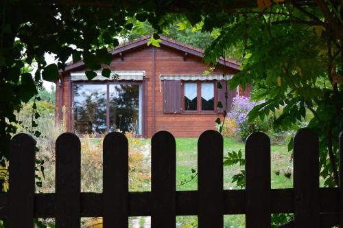 a wooden fence in front of a small house at Domaine de la Ribiere in Pagéas