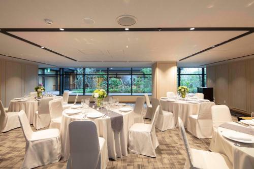 a room with white tables and white chairs and windows at Hyatt Regency Tokyo Bay in Urayasu