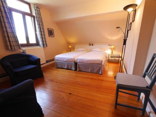a bedroom with a bed and a chair in it at L'Étape Fagnarde - Bed, Breakfast & Sauna in Spa