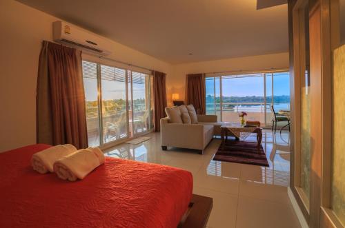 a bedroom with a bed and a living room with a view at Kwan Ruen Park in Nakhon Ratchasima